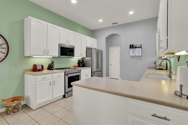 25105 Laurel Valley Rd, Leesburg, FL 34748 - kitchen with appliances with stainless steel finishes, white cabinetry, a peninsula, light tile patterned floors, and recessed lighting