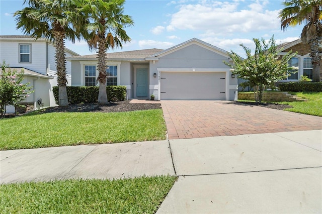 3142 Hill Point St, Minneola, FL 34715 - ranch-style house with decorative driveway, a garage, stucco siding, and a front yard