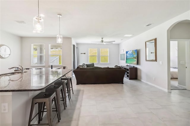 3142 Hill Point St, Minneola, FL 34715 - living area featuring arched walkways, a ceiling fan, and light tile patterned flooring