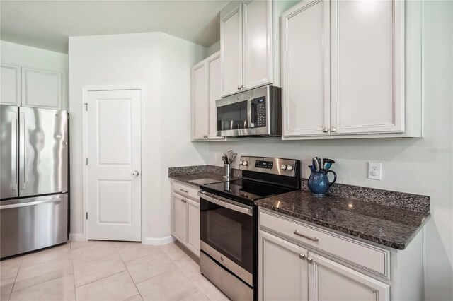 3142 Hill Point St, Minneola, FL 34715 - kitchen featuring stainless steel appliances, dark stone counters, and light tile patterned flooring