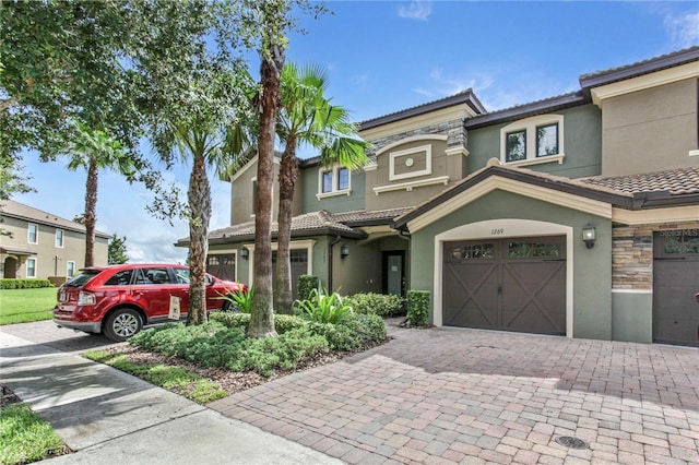 1269 Long Cove Loop Unit 1269, Davenport, FL 33896 - view of property with a tile roof, decorative driveway, stucco siding, and stone siding