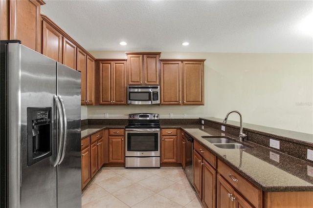 1269 Long Cove Loop Unit 1269, Davenport, FL 33896 - kitchen with appliances with stainless steel finishes, brown cabinetry, a peninsula, light tile patterned floors, and recessed lighting