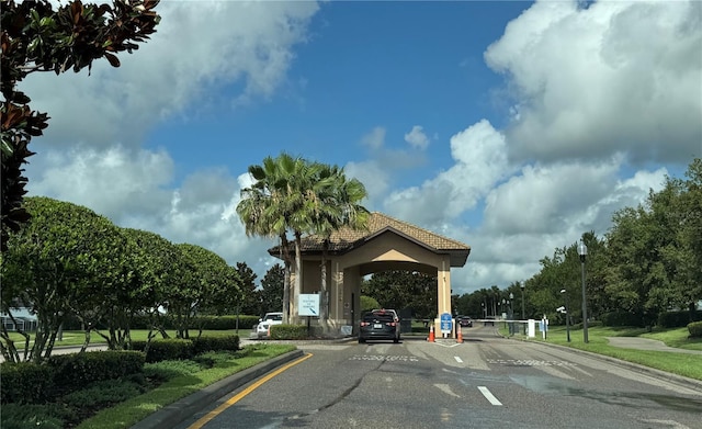 1269 Long Cove Loop Unit 1269, Davenport, FL 33896 - view of asphalt road with curbs, street lighting, a gated entry, and traffic signs