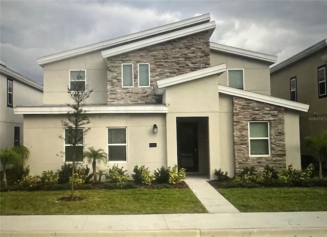 1201 Challenge Dr, Davenport, FL 33896 - view of front facade featuring stone siding, stucco siding, and a front lawn
