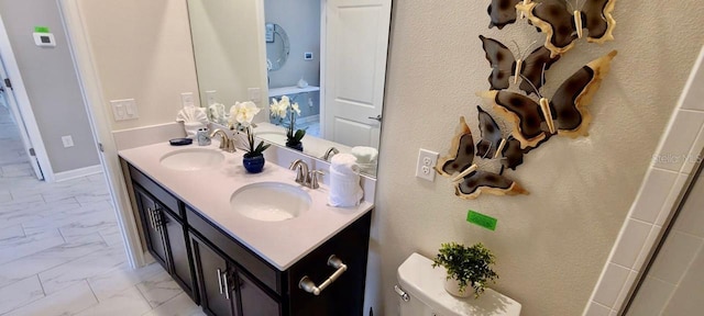1201 Challenge Dr, Davenport, FL 33896 - bathroom featuring marble look tiles and double vanity