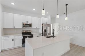 4572 SW 149th St, Ocala, FL 34473 - kitchen featuring appliances with stainless steel finishes, light wood-style floors, white cabinetry, a center island with sink, and recessed lighting