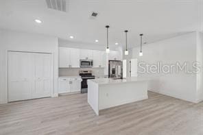 4572 SW 149th St, Ocala, FL 34473 - kitchen featuring stainless steel appliances, light wood-type flooring, white cabinetry, a kitchen island with sink, and recessed lighting