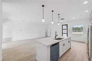 4572 SW 149th St, Ocala, FL 34473 - kitchen with dishwashing machine, light wood-type flooring, white cabinets, pendant lighting, and recessed lighting