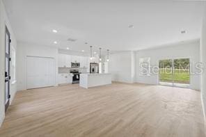 4572 SW 149th St, Ocala, FL 34473 - unfurnished living room with light wood-style floors and recessed lighting
