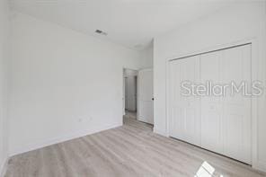 4572 SW 149th St, Ocala, FL 34473 - unfurnished bedroom with wood finished floors and a closet