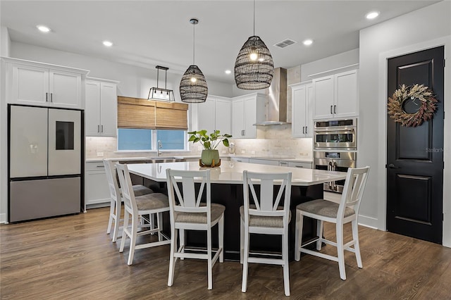 17290 Hickory Wind Dr, Clermont, FL 34711 - kitchen featuring white fridge, a kitchen island, wall chimney exhaust hood, double oven, and light countertops