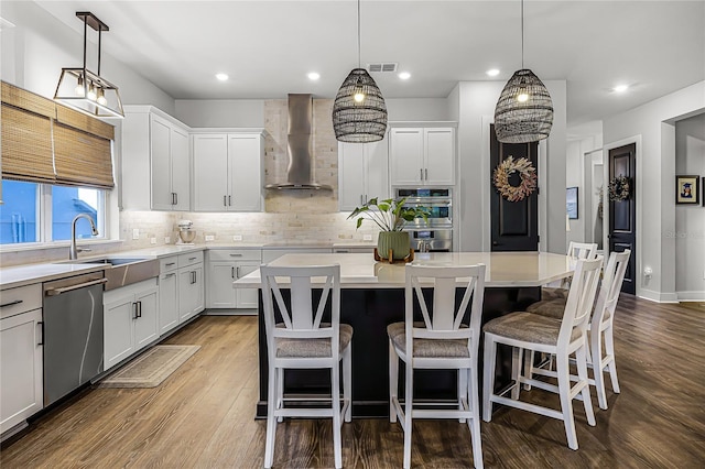17290 Hickory Wind Dr, Clermont, FL 34711 - kitchen with wall chimney exhaust hood, stainless steel appliances, backsplash, light countertops, and a kitchen island