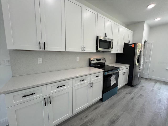569 Marion Oaks Mnr, Ocala, FL 34473 - kitchen featuring appliances with stainless steel finishes, light wood-style floors, white cabinets, recessed lighting, and light stone counters