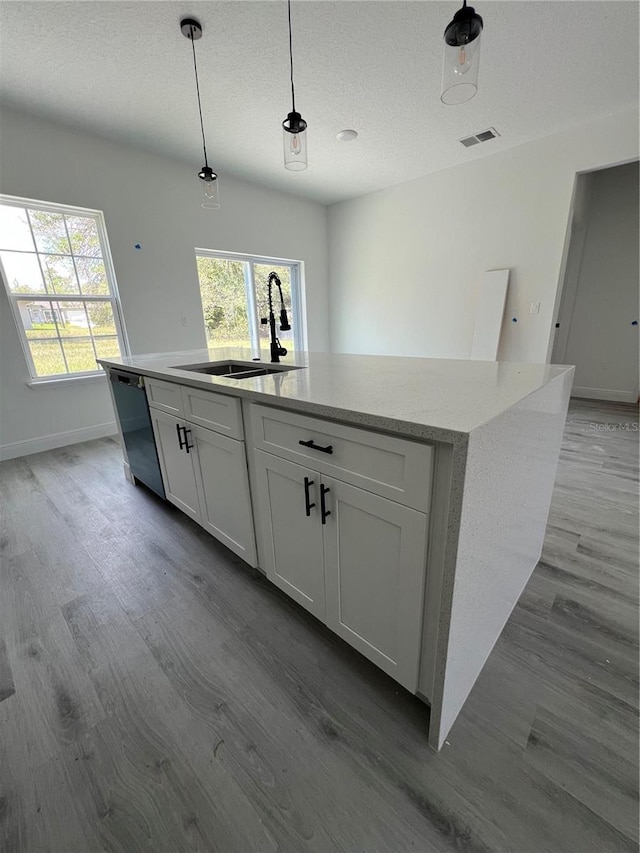 569 Marion Oaks Mnr, Ocala, FL 34473 - kitchen with a kitchen island with sink, dishwasher, wood finished floors, white cabinetry, and a textured ceiling
