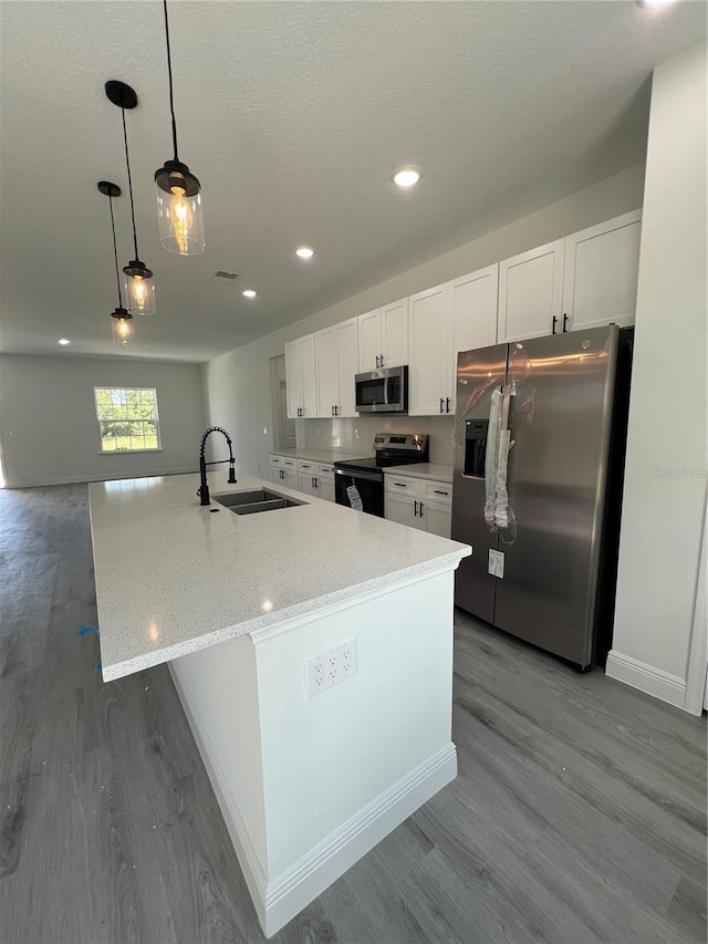 569 Marion Oaks Mnr, Ocala, FL 34473 - kitchen with stainless steel appliances, wood finished floors, white cabinetry, a spacious island, and recessed lighting