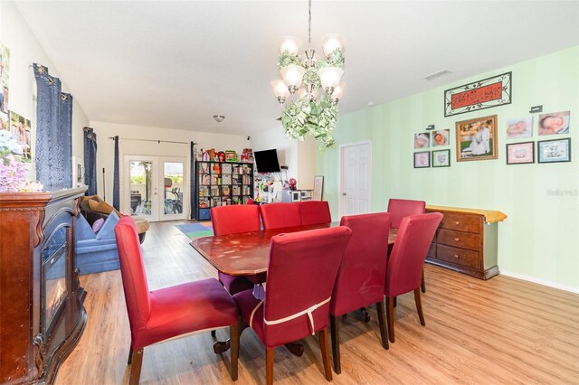 30308 Cheval St, Mount Dora, FL 32757 - dining space with light wood finished floors, a chandelier, and a fireplace