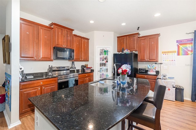 30308 Cheval St, Mount Dora, FL 32757 - kitchen featuring black appliances, light wood-style flooring, an island with sink, a breakfast bar, and recessed lighting