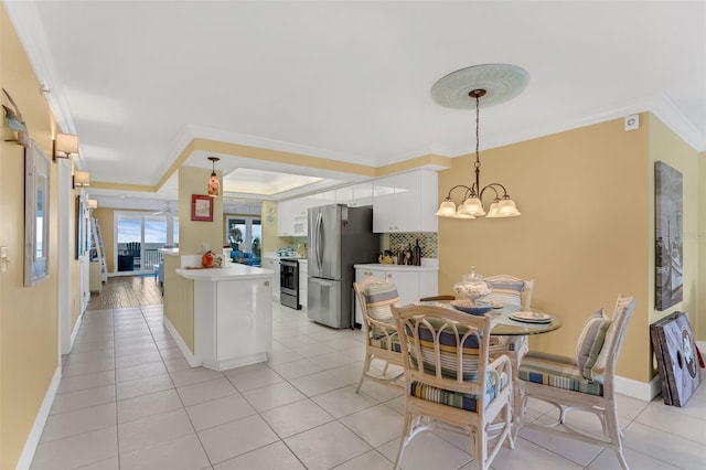 4631 S Atlantic Ave Unit 8102, Port Orange, FL 32127 - kitchen featuring stainless steel appliances, crown molding, white cabinetry, light countertops, and a chandelier