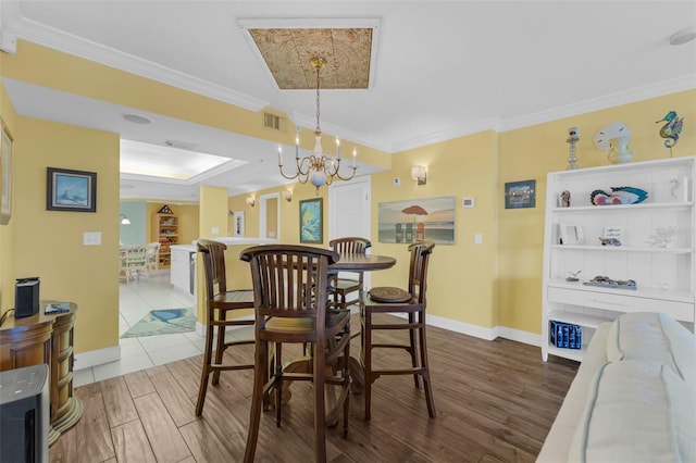 4631 S Atlantic Ave Unit 8102, Port Orange, FL 32127 - dining area with crown molding, a chandelier, dark wood finished floors, and a raised ceiling