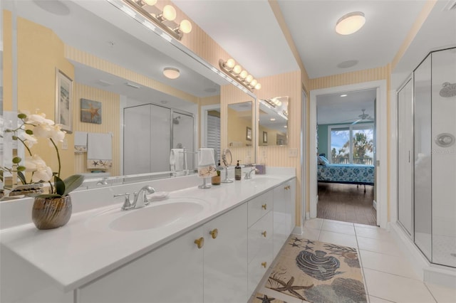 4631 S Atlantic Ave Unit 8102, Port Orange, FL 32127 - ensuite bathroom featuring a shower stall, double vanity, tile patterned flooring, and wallpapered walls