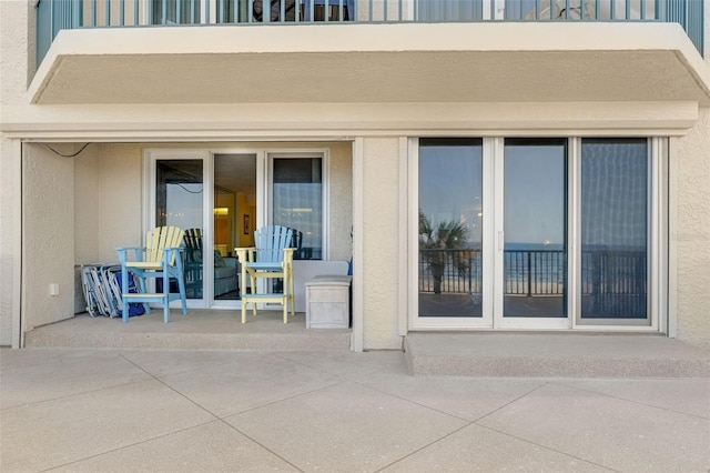 4631 S Atlantic Ave Unit 8102, Port Orange, FL 32127 - view of exterior entry with stucco siding and a patio area
