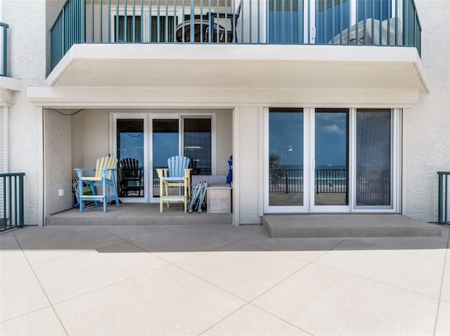 4631 S Atlantic Ave Unit 8102, Port Orange, FL 32127 - back of property featuring a balcony, stucco siding, and a patio
