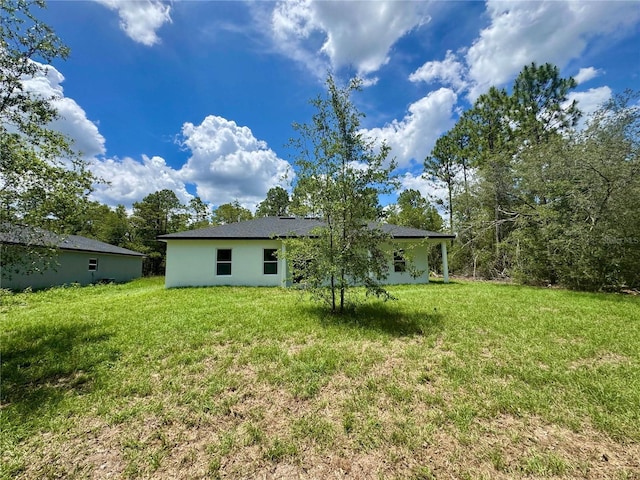 142 W Diego Pl, Citrus Springs, FL 34434 - back of house with a lawn and stucco siding