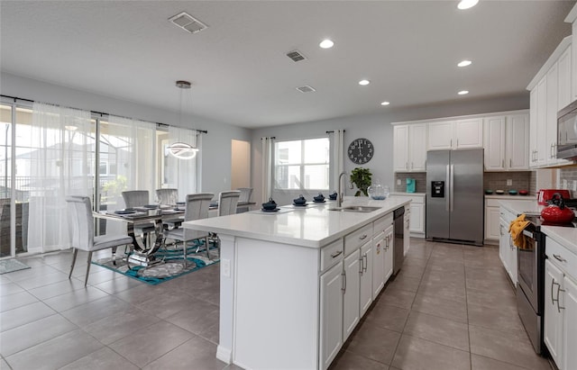 1811 Caribbean View Ter, Kissimmee, FL 34747 - kitchen with appliances with stainless steel finishes, light countertops, recessed lighting, backsplash, and a center island with sink