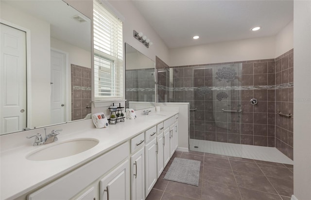 1811 Caribbean View Ter, Kissimmee, FL 34747 - bathroom featuring double vanity, a tile shower, tile patterned flooring, and recessed lighting