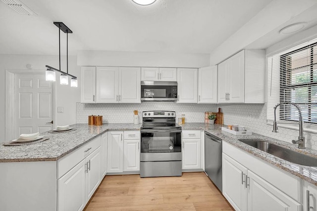 5460 SE 28th St, Ocala, FL 34480 - kitchen with stainless steel appliances, a peninsula, and white cabinetry