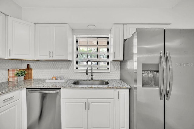 5460 SE 28th St, Ocala, FL 34480 - kitchen featuring appliances with stainless steel finishes, white cabinets, decorative backsplash, and light stone countertops
