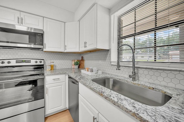 5460 SE 28th St, Ocala, FL 34480 - kitchen with appliances with stainless steel finishes, decorative backsplash, and white cabinets