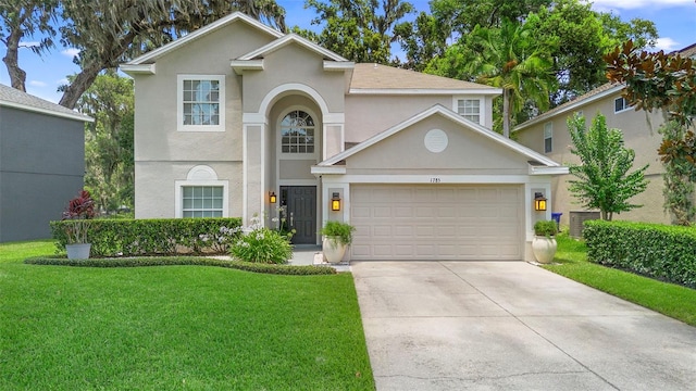 1785 Rushden Dr, Ocoee, FL 34761 - traditional home featuring stucco siding, a front yard, concrete driveway, and an attached garage