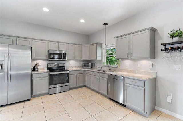 1785 Rushden Dr, Ocoee, FL 34761 - kitchen with appliances with stainless steel finishes, gray cabinets, light tile patterned floors, decorative light fixtures, and recessed lighting