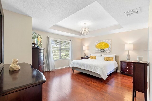 1785 Rushden Dr, Ocoee, FL 34761 - bedroom with a raised ceiling, a chandelier, dark wood-type flooring, and a textured ceiling