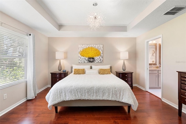 1785 Rushden Dr, Ocoee, FL 34761 - bedroom with wood finished floors, a raised ceiling, a chandelier, and connected bathroom