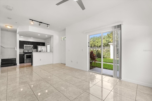 2280 San Vital Dr Unit 101, Kissimmee, FL 34741 - unfurnished living room with a ceiling fan, rail lighting, stairs, and light tile patterned floors