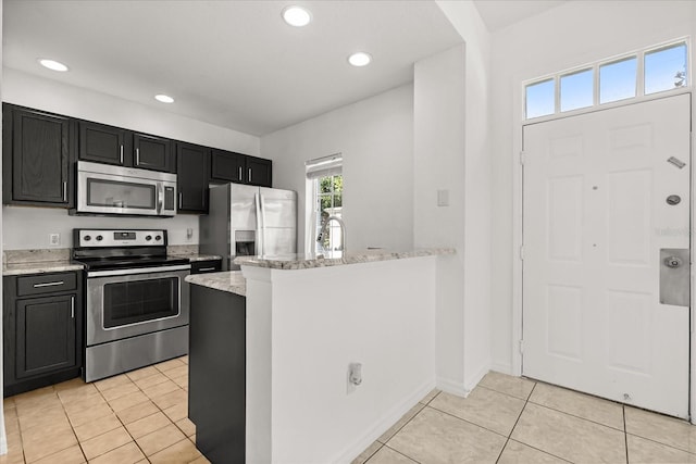 2280 San Vital Dr Unit 101, Kissimmee, FL 34741 - kitchen featuring stainless steel appliances, dark cabinets, light stone countertops, light tile patterned flooring, and recessed lighting