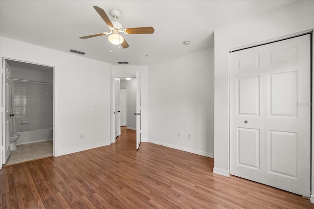 2280 San Vital Dr Unit 101, Kissimmee, FL 34741 - unfurnished bedroom featuring wood finished floors, ensuite bath, a closet, and a ceiling fan