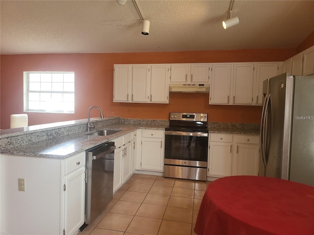 3013 Barrymore Ct, Orlando, FL 32835 - kitchen with stainless steel appliances, under cabinet range hood, white cabinetry, rail lighting, and a textured ceiling