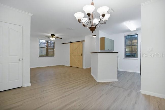 710 Siena Palm Dr Unit 104, Celebration, FL 34747 - kitchen featuring a barn door, dark countertops, light wood-style floors, a chandelier, and a ceiling fan