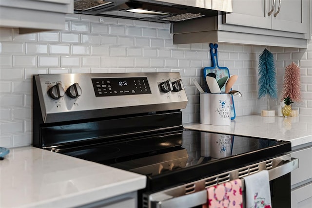 1388 Lombardi Ct, Kissimmee, FL 34759 - kitchen view of stainless steel electric stove, decorative backsplash, and extractor fan