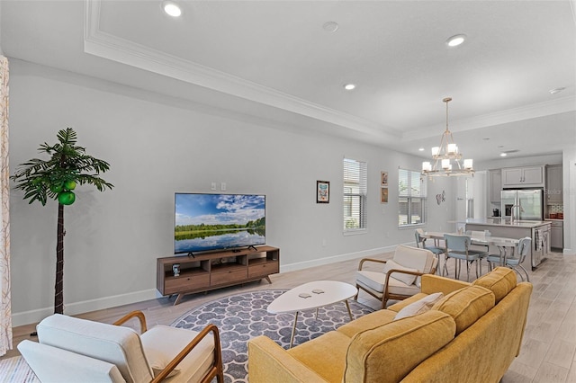 1388 Lombardi Ct, Kissimmee, FL 34759 - living room with a tray ceiling, recessed lighting, a chandelier, ornamental molding, and light wood-type flooring