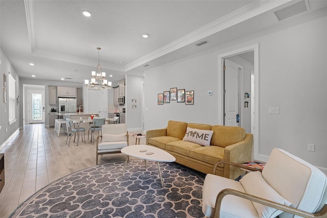 1388 Lombardi Ct, Kissimmee, FL 34759 - living area with recessed lighting, a raised ceiling, light wood-style flooring, a chandelier, and ornamental molding