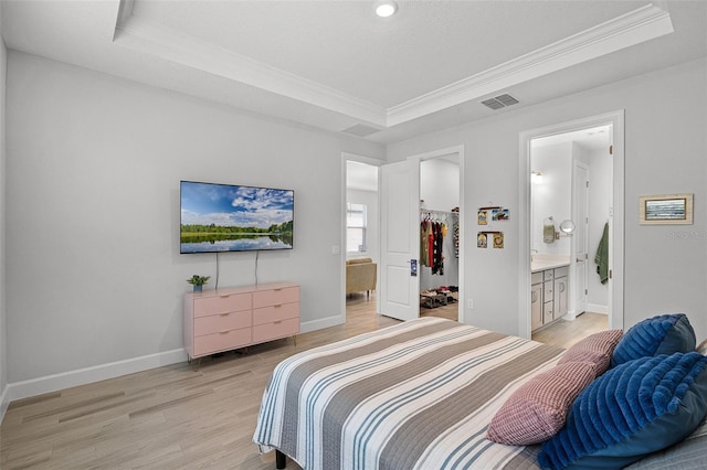 1388 Lombardi Ct, Kissimmee, FL 34759 - bedroom featuring a tray ceiling, a spacious closet, crown molding, light wood-style floors, and ensuite bathroom