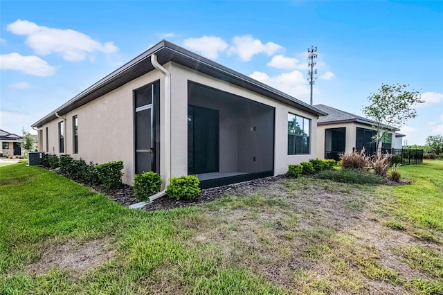1388 Lombardi Ct, Kissimmee, FL 34759 - rear view of property with a yard, stucco siding, and a sunroom