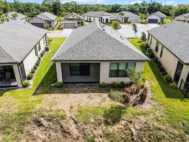 1388 Lombardi Ct, Kissimmee, FL 34759 - back of property featuring roof with shingles, a residential view, stucco siding, and a yard
