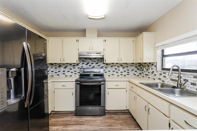 3460 Tomahawk Ave, Spring Hill, FL 34606 - kitchen featuring fridge with ice dispenser, stainless steel electric stove, under cabinet range hood, a textured ceiling, and light countertops