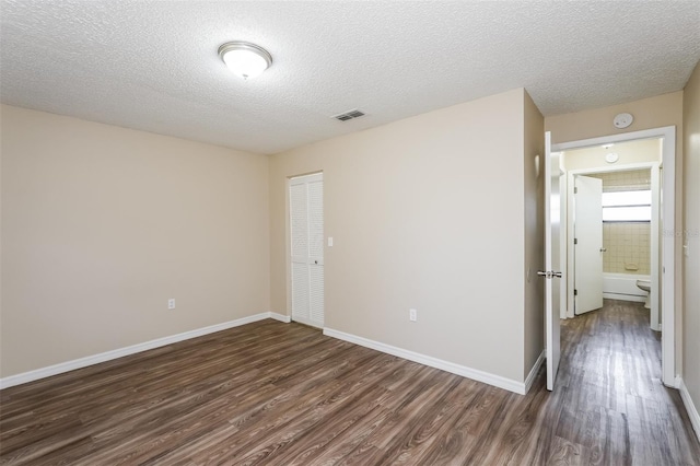 3460 Tomahawk Ave, Spring Hill, FL 34606 - empty room with dark wood-type flooring, a smoke detector, and a textured ceiling