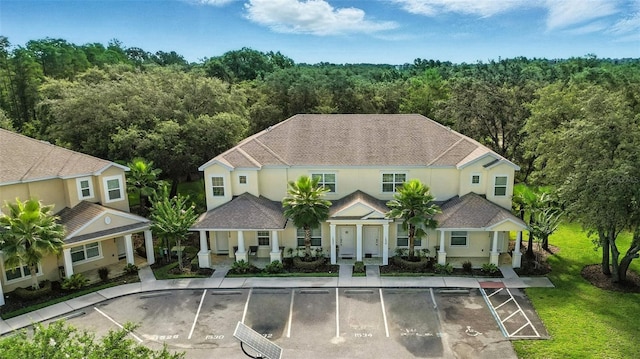 1530 Retreat Cir, Clermont, FL 34714 - back of house with uncovered parking, a view of trees, stucco siding, and a porch
